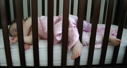 She never stays inside the bars.  Makes us hesitate putting her in a a big kid bed.