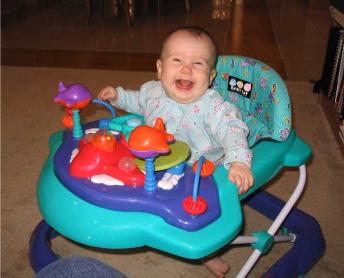 Here's the Audj-meister in her walker that's shaped like an airplane!  She likes it a lot.  She's smiling so big, in fact, that you can't even see her eyes!